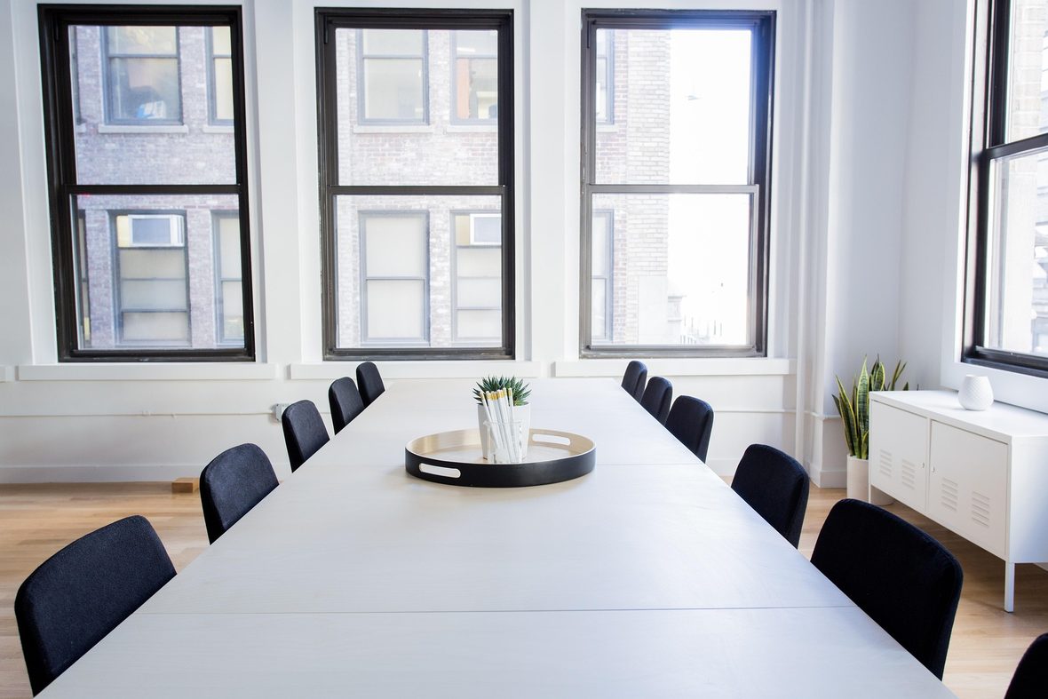 A bright conference room arranged for a meeting around a shared table